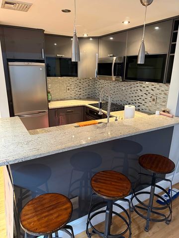 Manchester apartment for rent - A kitchen with a bar stool and a refrigerator.