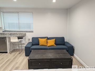 State College apartment for rent - A living room with a blue couch and a wooden coffee table.