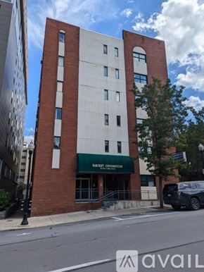 State College apartment for rent - A tall red and white building with a green awning on the front.