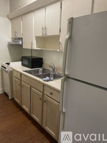 Orlando apartment for rent - A kitchen with a white fridge and wooden cabinets.