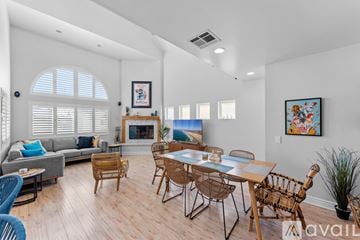 Oxnard house for rent - A living room with a grey couch, a fireplace, and a dining table with chairs.