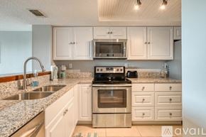 St. Augustine apartment for rent - A kitchen with white cabinets and granite countertops.