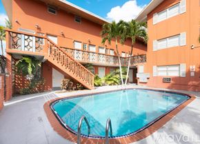 Miami apartment for rent - A small pool in front of a building with a staircase.