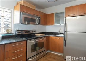 Miami apartment for rent - A kitchen with wooden cabinets and a black countertop.