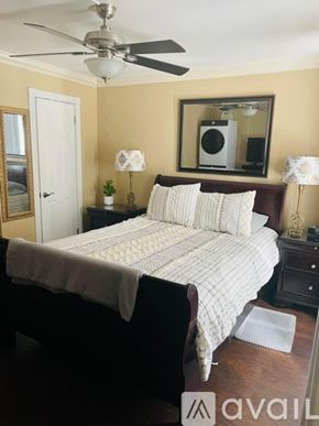 St. Petersburg house for rent - A bedroom with a bed, two lamps, and a mirror.