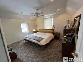 Traverse City apartment for rent - A bedroom with a bed, dresser, and ceiling fan.
