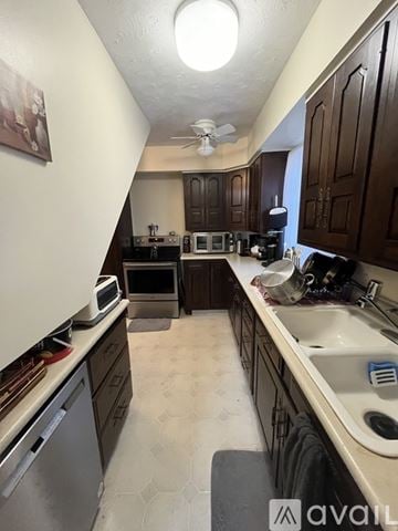 Traverse City apartment for rent - A kitchen with brown cabinets and a white dishwasher.