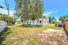 St. Petersburg house for rent - A backyard with a tree, a fence, and a house.