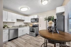 St. Petersburg house for rent - A kitchen with white cabinets and a wooden table.