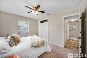 St. Petersburg house for rent - A bedroom with a white bed and a ceiling fan.