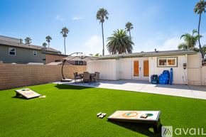 Ventura house for rent - A backyard with a lawn, a table, chairs, and a pool table.