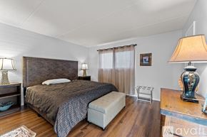 Wickenburg apartment for rent - A bedroom with a large bed and a bench in front of it.