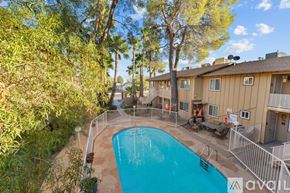 Wickenburg apartment for rent - A swimming pool surrounded by a fence and trees.
