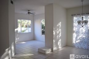 Camarillo house for rent - A room with a fan, a chandelier, and a window with a view of trees.