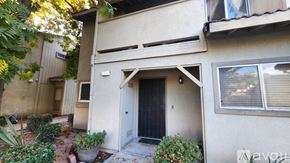 Modesto townhouse for rent - A house with a black door and a window with blinds.