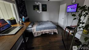 Modesto townhouse for rent - A laptop is open on a wooden desk in a room with a bed and a TV.