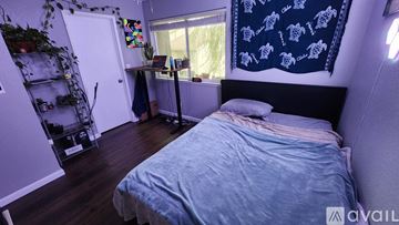 Modesto townhouse for rent - A bedroom with a bed, desk, and a window with a curtain.