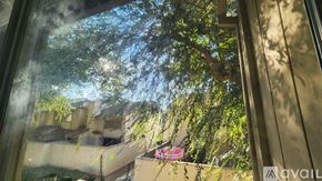 Modesto townhouse for rent - A view from inside a building looking out to a courtyard with trees and a building in the distance.