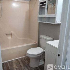 Cleveland apartment for rent - A small bathroom with a toilet, sink, and bathtub.