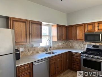 Long Beach house for rent - A kitchen with wooden cabinets and a white refrigerator.