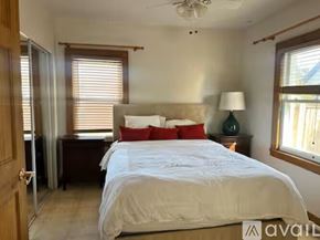 Long Beach house for rent - A bedroom with a large bed and a ceiling fan.