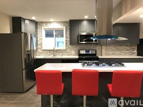 Antioch apartment for rent - A modern kitchen with a white island and red chairs.