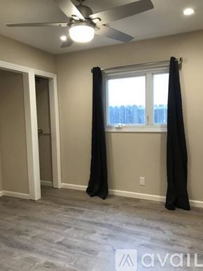 Antioch apartment for rent - A room with a ceiling fan and a window with curtains.