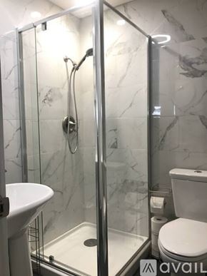 Antioch apartment for rent - A bathroom with a marble wall and a glass shower stall.