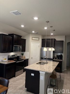 Burnet house for rent - A kitchen with black cabinets and granite countertops.