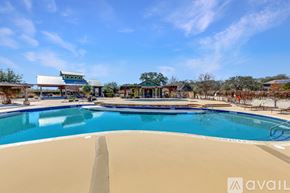 Schertz house for rent - A large swimming pool with a blue sky and clouds in the background.