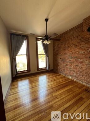 Dekalb apartment for rent - A room with wooden floors and a brick wall.
