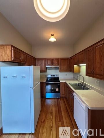 Dekalb apartment for rent - A kitchen with wooden cabinets and a white fridge.