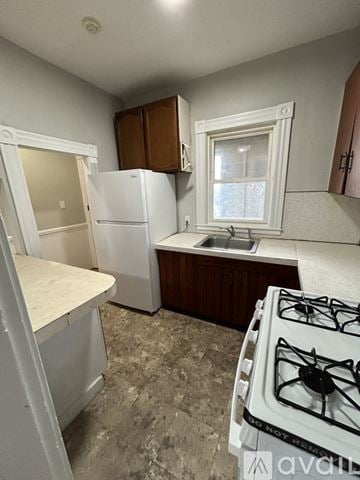 Gardner apartment for rent - A kitchen with a white fridge, a white stove, and a window.