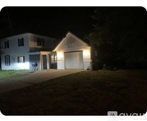 Magnolia house for rent - A house with a garage is illuminated by its own lights at night.