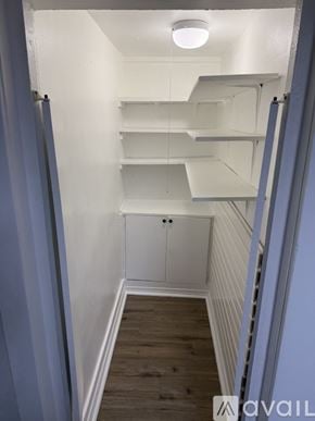Berwyn apartment for rent - A narrow hallway with white shelves and a cabinet.