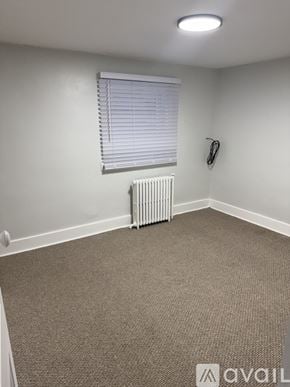 Berwyn apartment for rent - A carpeted room with a window and a radiator.