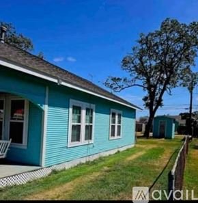 Freeport house for rent - A blue house with a white chair on the porch.