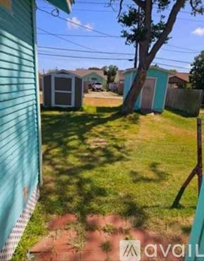 Freeport house for rent - A backyard with a tree, a shed, and a fence.