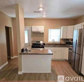 Freeport house for rent - A kitchen with white cabinets and a granite countertop.