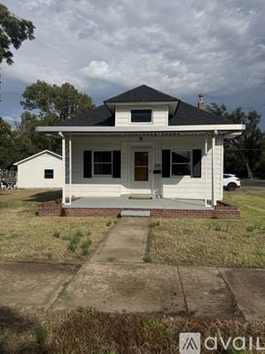 Salina house for rent - A white house with a black roof and a porch.