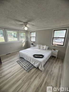 Salina house for rent - A bedroom with a bed, nightstand, and window.