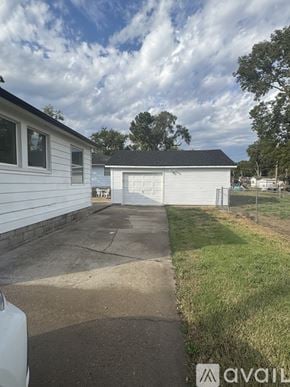 Salina house for rent - A white house with a garage is situated in a grassy area.
