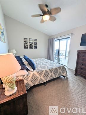 North Topsail Beach condo for rent - A bedroom with a bed, dresser, and ceiling fan.