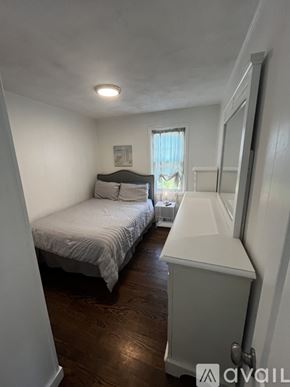 Narragansett house for rent - A bedroom with a bed, dresser, and window.