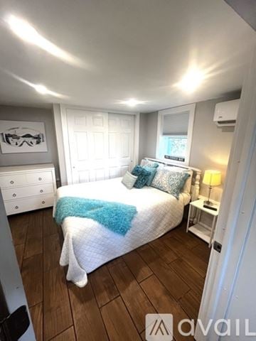 Narragansett house for rent - A bedroom with a bed, nightstand, and window.