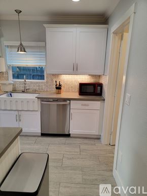 Sacramento townhouse for rent - A kitchen with white cabinets and a microwave on the counter.