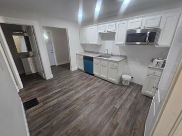 Lima house for rent - A kitchen with white cabinets and a blue island.