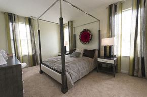 Cranford apartment for rent - A bedroom with a four poster bed and a wreath on the wall.