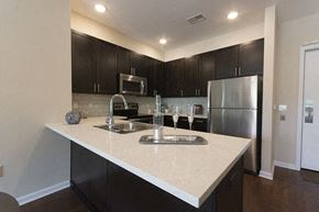 Cranford apartment for rent - A kitchen with a white counter top and black cabinets.