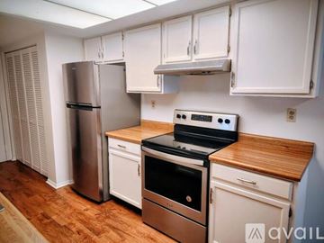 Fairborn condo for rent - A kitchen with white cabinets and a wooden countertop.